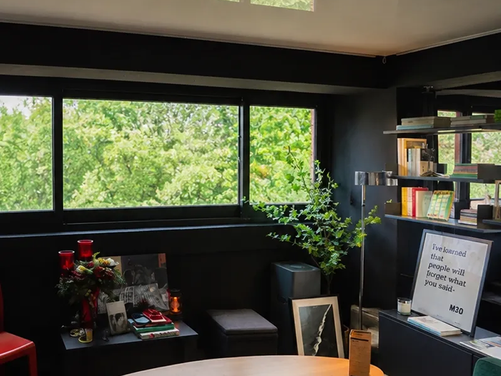A cozy reading lounge in one of the best book cafes in Seoul for solo visitors, featuring a green sofa, bookshelv
