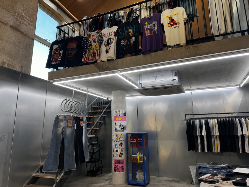 Seoul vintage shops with rows of vintage jackets, sweaters, shirts, and colorful secondhand clothing in an industrial-style vintage clothing store.