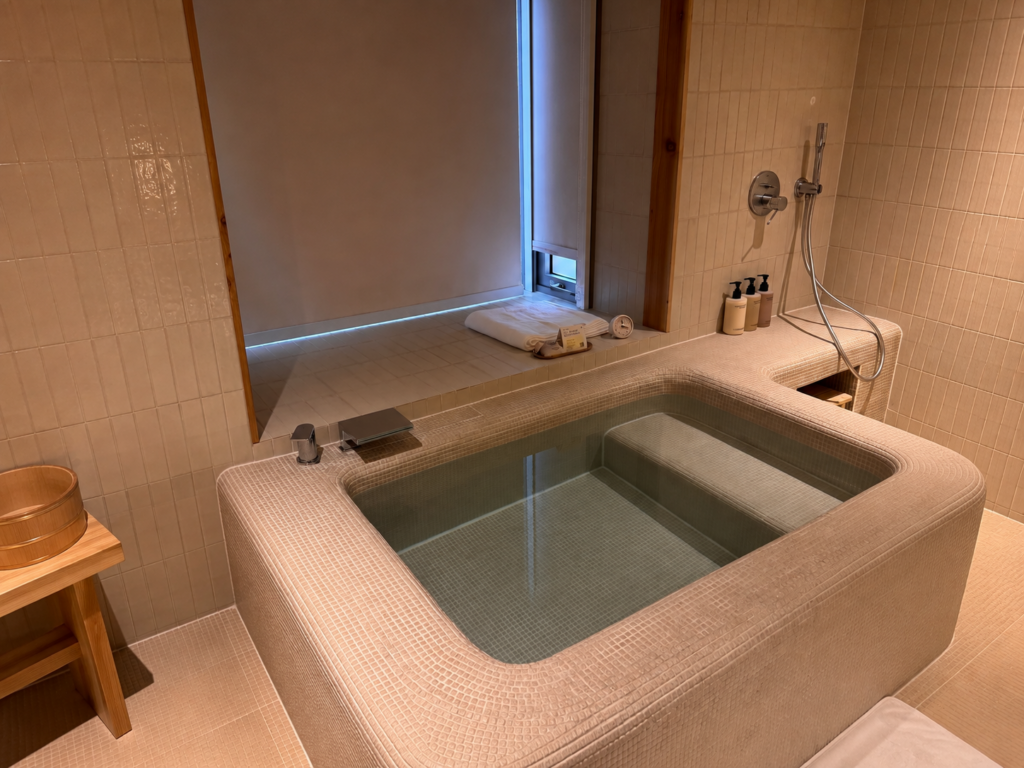 The Private Sauna in Seoul bathroom with a private tiled soaking tub, shower, and cozy sauna-inspired interior